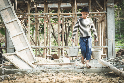 Children working at construction sites are forced to work. The concept of anti-child labor. The abuse of labor. The oppression or intimidation of forced labor among children.