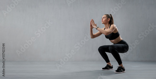 Wallpaper Mural Sports woman in fashion black sport clothes squatting doing sit-ups in gym, over