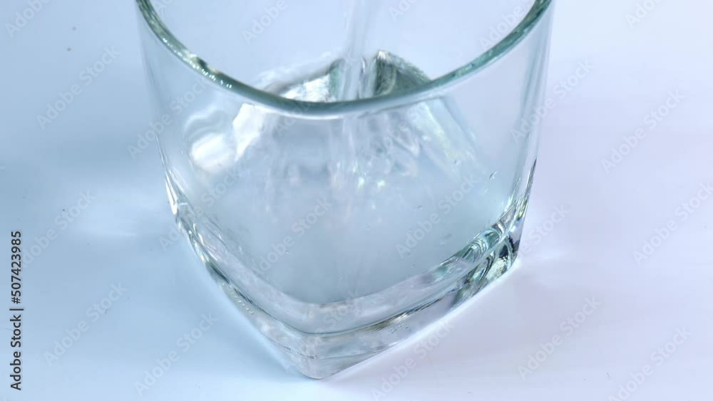 Take a shot in a clear glass with hot water. Water gradually rising, photo gradually zoomed out, studio shot, white background. Take a shot in a clear glass with hot water. Water gradually rising, photo gradually zoomed out, studio shot, white background.
