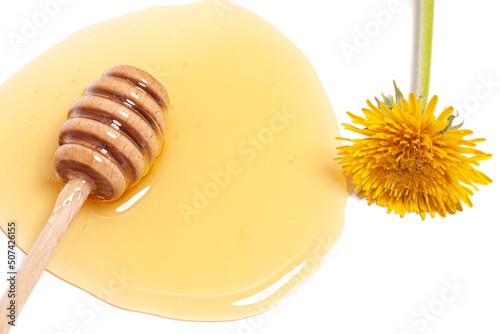 Wooden dipper with honey and dandelion isolated on a white background. Golden organic floral honey natural.