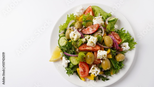 Greek salad. Fresh vegetable salad with tomato, onion, cucumbers, sweet pepper, olives, olive oil, lettuce, red onion, and feta cheese.
