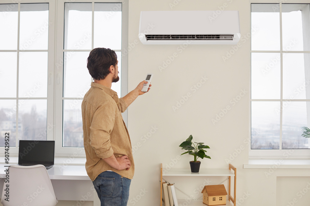 Man Climate Control Computer Man with remote control from air conditioner creates comfortable ...