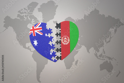 puzzle heart with the national flag of afghanistan and australia on a world map background. Concept.