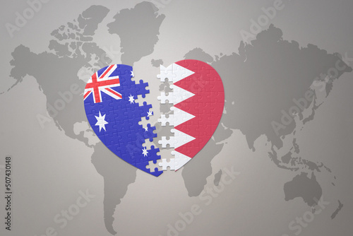 puzzle heart with the national flag of bahrain and australia on a world map background. Concept.