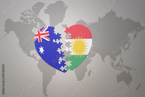puzzle heart with the national flag of kurdistan and australia on a world map background. Concept.