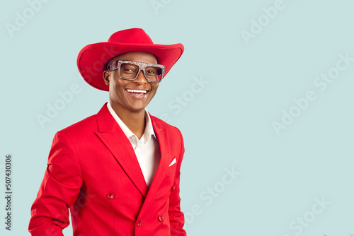 Quadro em tela Portrait of happy extravagant dark skinned showman on pastel light blue background