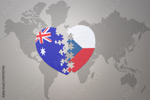 puzzle heart with the national flag of czech republic and australia on a world map background. Concept.