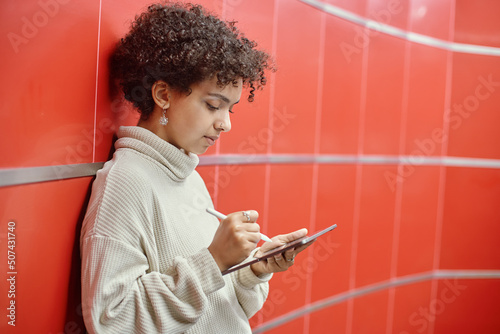 Obraz na płótnie young woman with a digital tablet standing near the wall in the subway . w salonie