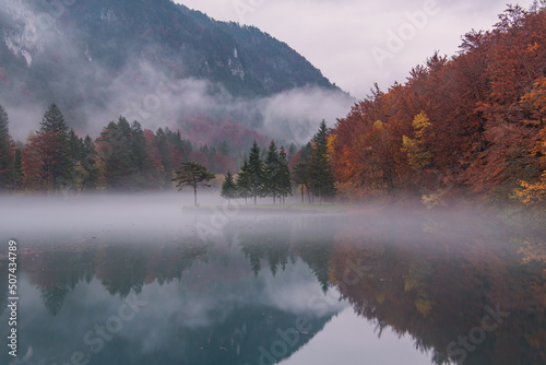 Autumn reflections at the emerald lake. Location is Zavrsnica valley in Slovenia.