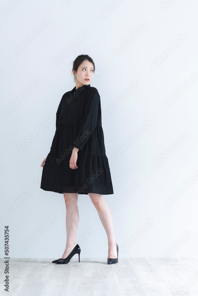 黒いワンピースを着たクールな女性