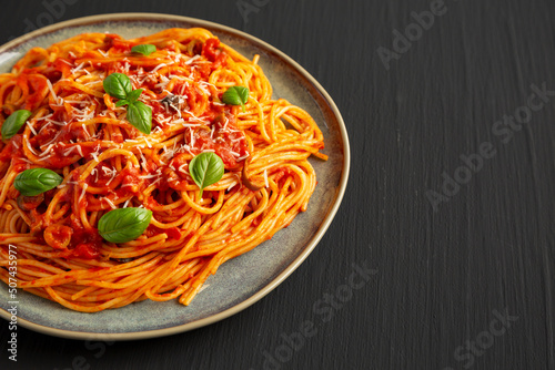 Homemade Spaghetti with Olives and Tomato Sauce on a Plate, side view. Copy space.