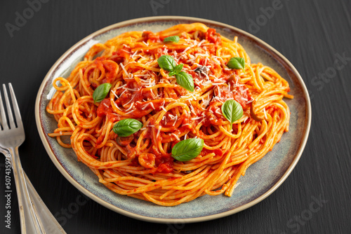 Homemade Spaghetti with Olives and Tomato Sauce on a Plate, side view. Close-up.