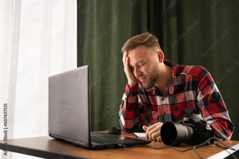 Frustrated Photographer off loading files on laptop. Checking photos working at modern office. editing his images on laptop. problem Frustrated Photographer off loading files on laptop. Checking photos working at modern office. editing his images on laptop. problem