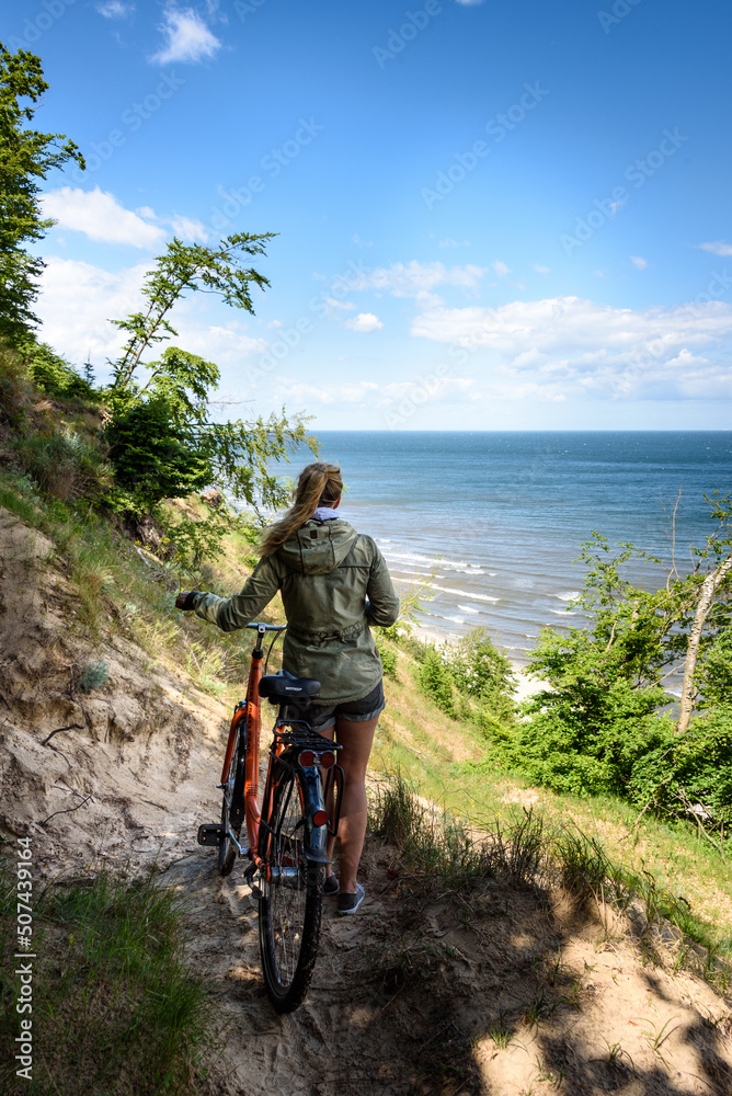Fototapeta premium Frau mit Fahrrad an der Ostseeküste von Usedom