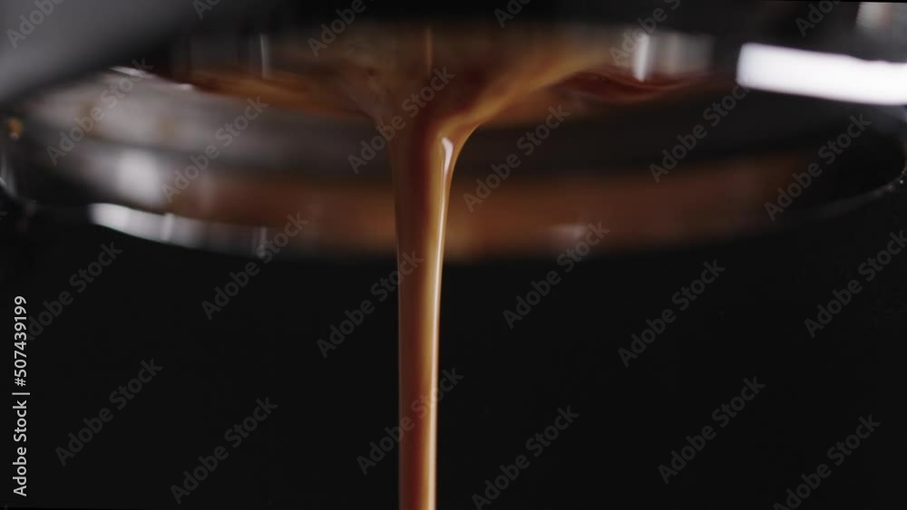 Slow motion macro shot of pulling espresso shot with bottomless portafilter