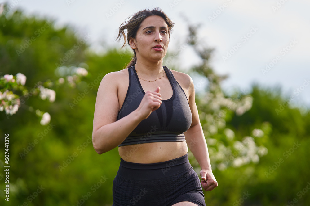 Plus size lady running through an orchard Plus size lady running through an orchard