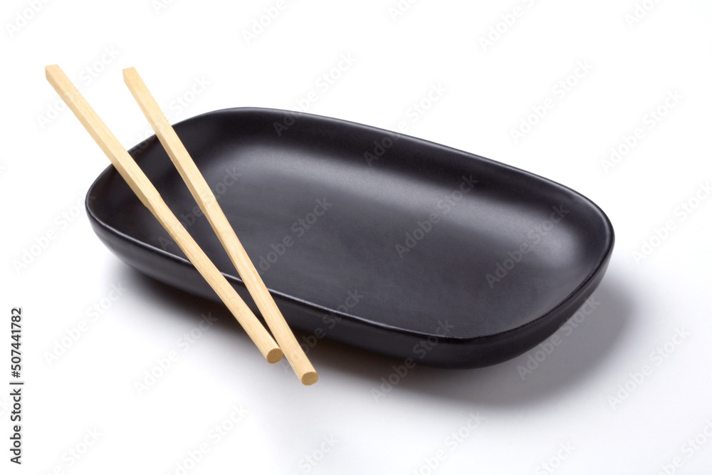 wooden chopsticks on black oval plate wooden chopsticks on black oval plate