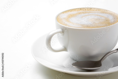Cappuccino coffee in white coffee cup with saucer and spoon