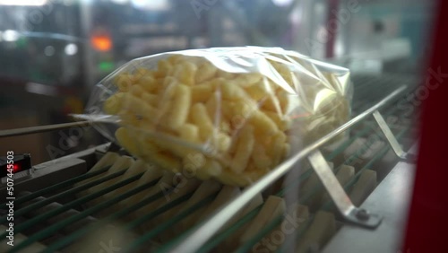 transparent packages of corn sticks move along the conveyor for further transportation. plant for the production of corn sticks.