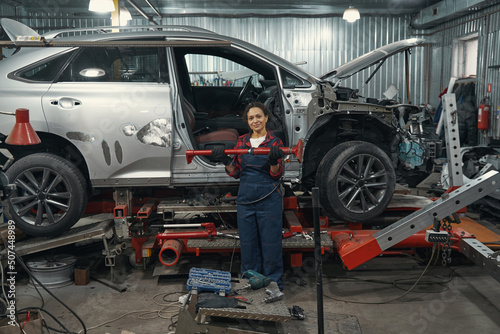 Wallpaper Mural Female auto mechanic standing near vehicle in car garage Torontodigital.ca