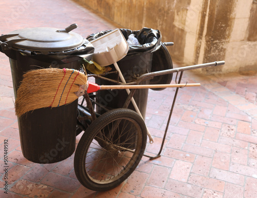 trolley with waste bin and garbage man s broom photo