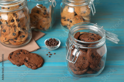 Foto Delicious chocolate chip cookies in glass jars on turquoise wooden table
