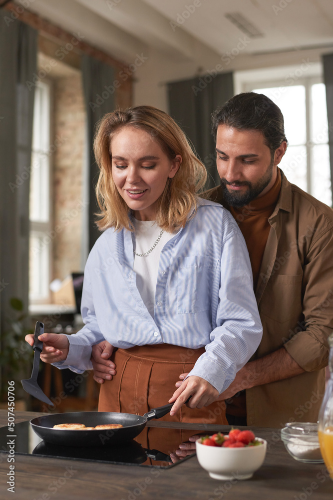 Portrait of beautiful young multi-ethnic couple spending morning in kitchen cooking breakfast together Portrait of beautiful young multi-ethnic couple spending morning in kitchen cooking breakfast together