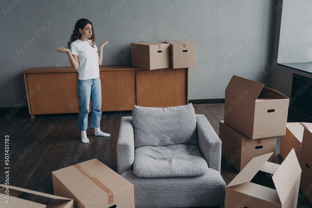Spanish woman feels hard to move alone exhausted with boxes packing. Delivery service ordering.