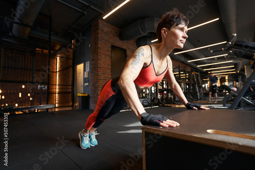Professional sportswoman doing strength exercise in fitness club