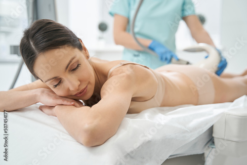 Satisfied client of beauty salon experiencing vela shape procedure