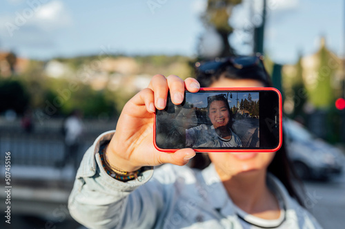 Asian woman traveler taking a selfie in the city