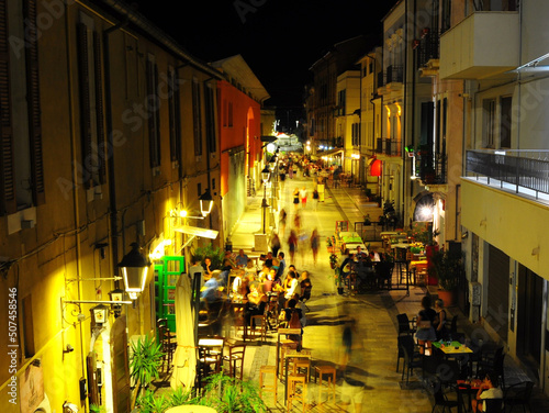 Persone camminano in strada tra i locali notturni movida ristoranti
