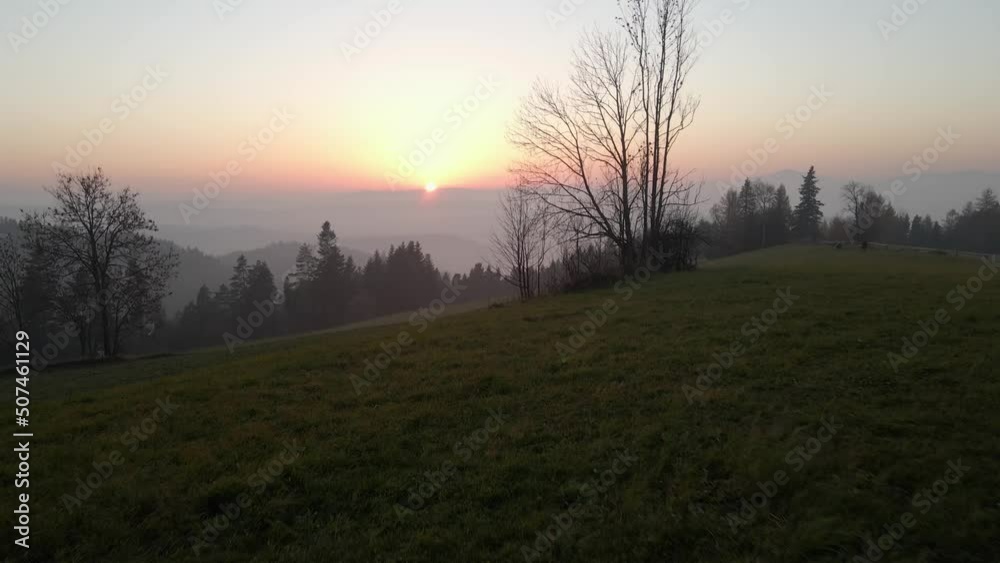 Flying forward over a fence during the sunset, revealing the forest and the moutains with mist Flying forward over a fence during the sunset, revealing the forest and the moutains with mist