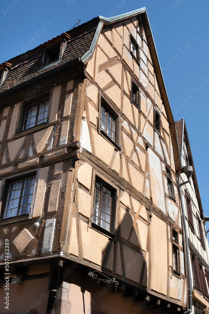 Old typical half-timbered house with yellow colour in the Rue des Marchands in Colmar, Alsace, France