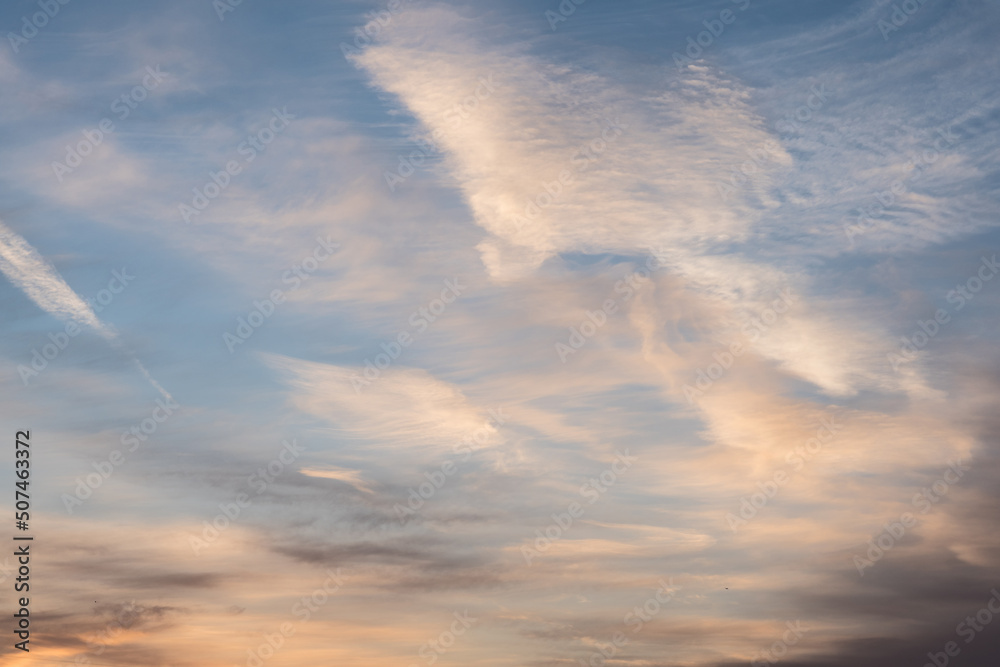 Twilight sky with effect of light pastel blue colors and trail of plane. Colorful sunset of soft clouds. Twilight sky with effect of light pastel blue colors and trail of plane. Colorful sunset of soft clouds.