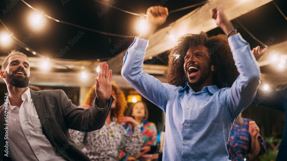Fototapeta premium Beautiful Carefree Friends are Dancing Together and Celebrating an Evening Event at a Party. Diverse Multiethnic Young Adult People Have Fun at a Corporate Party in a Restaurant.