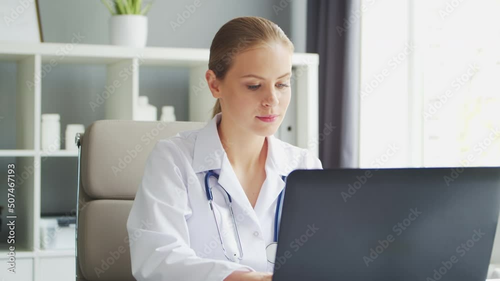 Doctor Works in the Medical Office. Woman in White Coat. Workplace of a Professional Female Therapist in a Hospital or Clinic. Healthcare and Medicine. Doctor Works in the Medical Office. Woman in White Coat. Workplace of a Professional Female Therapist in a Hospital or Clinic. Healthcare and Medicine.