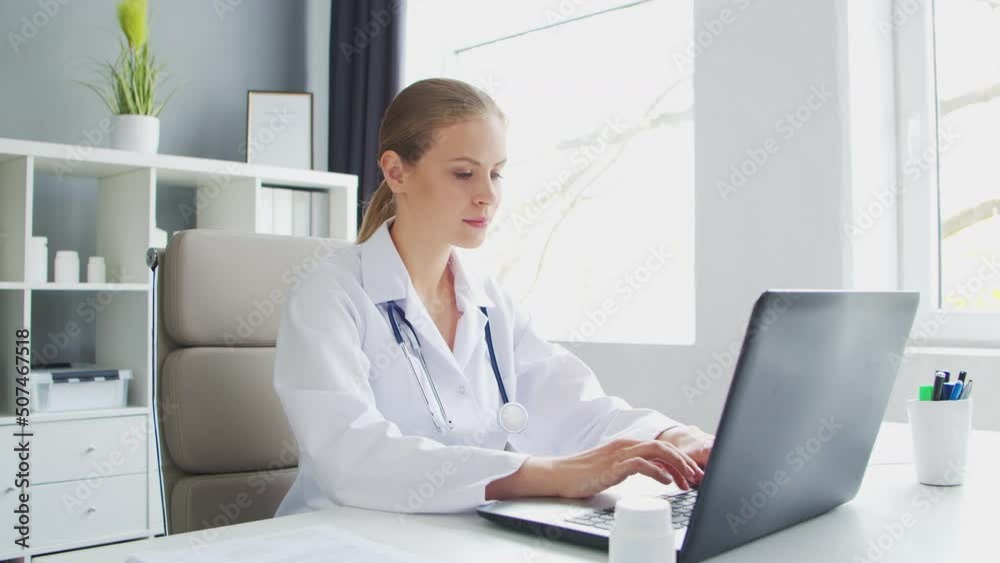 Doctor Works in the Medical Office. Woman in White Coat. Workplace of a Professional Female Therapist in a Hospital or Clinic. Healthcare and Medicine. Doctor Works in the Medical Office. Woman in White Coat. Workplace of a Professional Female Therapist in a Hospital or Clinic. Healthcare and Medicine.