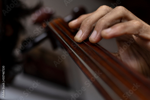 Close-up of the hand correctly placed in first position on the cello. Concept orchestra instrument and music student.