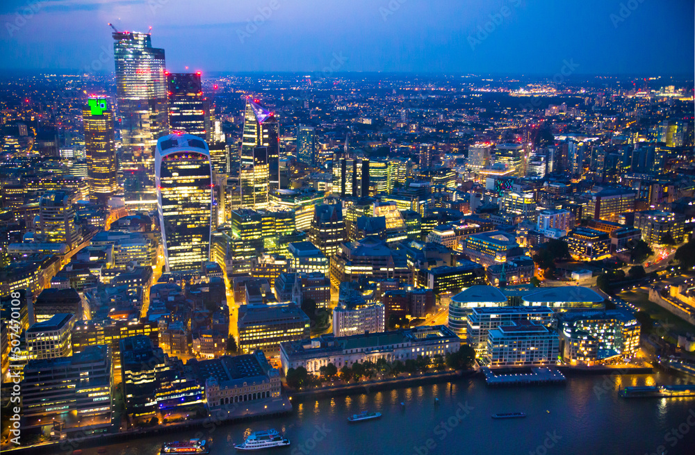 City of London at sunset. View include modern skyscrapers, banks and office buildings and river Thames