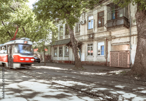 a rushing tram through the streets of an ancient city. public transport in an urban environment