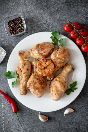 grilled chicken legs with spices on a stone background