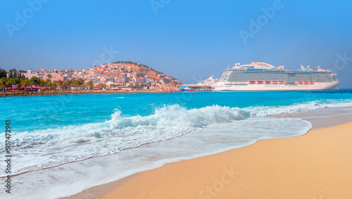 Panoramic beach landscape, Empty tropical beach and turquoise seascape - The cruise ship is located on Kusadasi Island in the port of Kusadasi, Turkey
