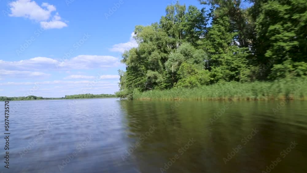 The boat floats along the river along the shore. View of the river from the boat. Pripyat river. Chernobyl Exclusion Zone. Ukraine.