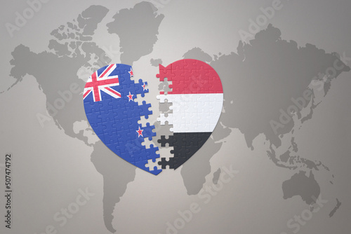 puzzle heart with the national flag of new zealand and yemen on a world map background. Concept. photo