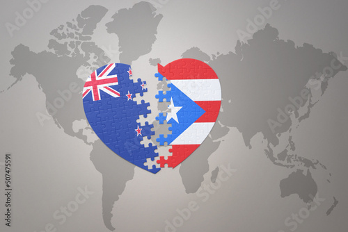 puzzle heart with the national flag of new zealand and puerto rico on a world map background. Concept.
