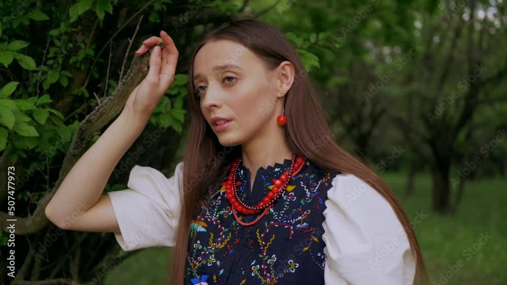 Ukrainian girl in a green garden. Beautiful woman in an embroidered dress walks in the park. Ukrainian girl in a green garden. Beautiful woman in an embroidered dress walks in the park.