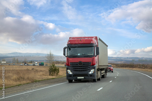 The truck is moving along a suburban highway. Cargo transportation, logistics. © Marina
