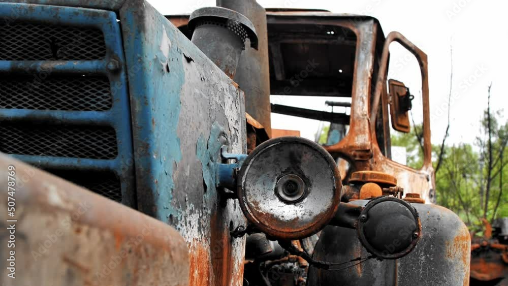 Close-up of a broken headlight of a burned-out tractor after a disaster, fire, military air attack. Affected civilian vehicles as a result of rocket and artillery shelling by Russia of Ukraine. Close-up of a broken headlight of a burned-out tractor after a disaster, fire, military air attack. Affected civilian vehicles as a result of rocket and artillery shelling by Russia of Ukraine.