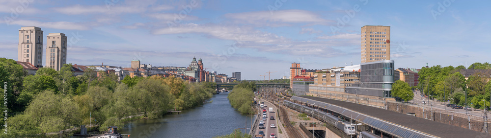 Panorama over the districts Kungsholmen and Vasastan water fronts at the canal Karlbergskanalen. Offices, the street Norra Länken and a rail yard a sunny summer day in Stockholm